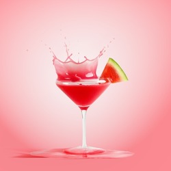 Red splashing drink in martini glass with watermelon at pink background. Delicious refreshing summer cocktail. Front view.