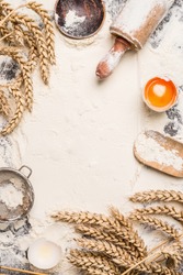 flour baking background with raw egg, rolling pin and wheat ear , top view