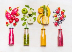 Assortment of fruit  and vegetables smoothies in glass bottles with straws on white wooden background. Fresh organic Smoothie ingredients. Superfoods and health or detox  diet food concept.