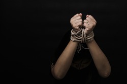 Slave Asian woman fears she was hands tied up with rope black background. Stop violence against kidnap trafficking, International Human Rights day
