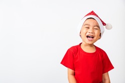 Portrait of Asian little cute boy smile and excited, Kid dressed in red Santa Claus hat the concept of holiday Christmas Xmas day or Happy new year, studio shot isolated on white backgroun