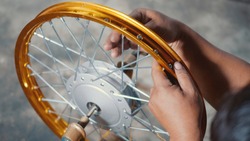 Technician man working motorcycle wheel has spokes weave up on mechanic new steel wheel, Motorcycle spokes wheel alignment machine tool