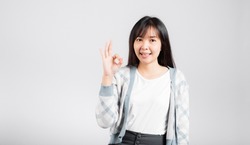Woman smiling showing made finger OK symbol sign to agree studio shot isolated white background, Happy Asian portrait beautiful young female lifestyle agree hand sign with copy space