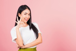 Portrait Asian beautiful young woman standing, She made finger OK symbol sign to agree side away looking at camera, studio shot isolated on pink background, Thai female agree hand sign copy space