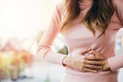 Asian young female suffers from stomachache after eating spoiled food, Abdominal pain from menstrual cramps, Sick woman unhappy having stomach ache digestive problem at home
