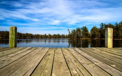 A Day At The Lake. Wooden dock overlooking a gorgeous lake in the wilderness.  Ludington State Park. Ludington, Michigan.  