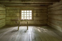 Empty Log Cabin Interior. Interior of a historic pioneer log cabin in the Smoky Mountains. This cabin is a historical display open to the public and is not a privately owned property or residence.