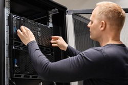 Male Technician Installing Servers In Enterprise Datacenter for Cloud Hosting