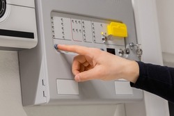Close-up of electrician Checking Fire Alarm Panel In Datacenter