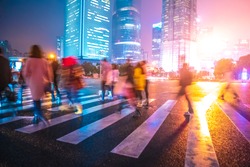 Abstract background of People across the crosswalk at night in Shanghai, China. Perfect background image of blurred night street with unrecognizable people and cars in night illumination 