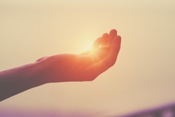 light, sun in human hand, spirituality and energy concept, praying hands
