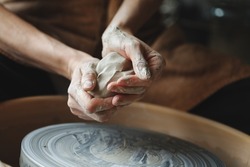 Woman hands working on pottery wheel making a clay pot, raw clay shaping, traditional craft