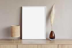 Blank white empty picture frame mockup on grey wall. Copy space. Artwork showcase. View of modern scandinavian style interior with chair. Home staging and minimalism concept