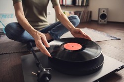 Woman listening to music, relaxing, enjoying life, having fun on home party. Turntable playing vinyl LP record. Leisure, lockdown, retro revival, hobby, lifestyle concept