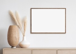 Blank white empty picture frame mockup on white wall. Artwork in interior design. Modern boho style interior with poster template