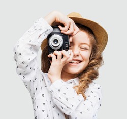 Cute little girl takes picture with vintage camera