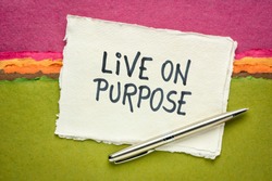 Live on purpose inspiraitonal note - handwriting on a handmade rag paper against abstract landscape, personal devleopment, goals and lifestyle concept