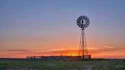 windmill with a water pump against sunrise in shortgrass prairie, Pawnee National Grassland in Colorado