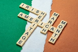 March - National Irish American Heritage Month, crossword on a paper abstract in colors of national flag of Ireland (green, white and orange), reminder of cultural event and celebration