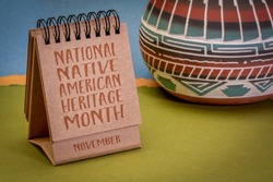 November - National Native American Heritage Month, handwriting in a desktop calendar with ceramic vase against abstract paper landscape, reminder of historical and cultural event