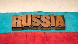 Russia word abstract in vintage letterpress wood type against paper abstract in colors of RUssian national flag