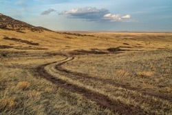 dirt ranch road in grassland in northern Colorado, early spring scenery of Soapstone Prairie Natural Area near Fort Collins