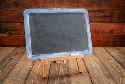 blank slate blackboard easel sign on a rustic weathered wood, retro classroom concept
