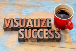 visualize success banner  - text in vintage letterpress wood type blocks stained by color inks against grunge wood with a cup of coffee