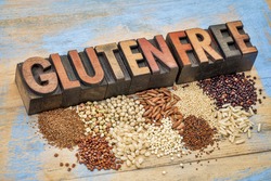 selection of gluten free grains (quinoa, rice, teff, buckwheat, sorghum,kaniwa, amaranth) and text in vintage letterpress wood type  against painted wood