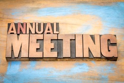annual meeting word abstract in letterpress wood type against grunge wooden background