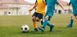 Running Footballers. Children Kicking Soccer School Tournament Match. Multiethnic Children Playing Sports. Young Athletes Compete in Football Game