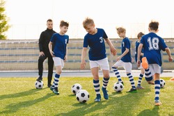 Football Education for Kids. Physical Education for Children. Young Coach With Kids in Soccer Team on Training Unit. Youth Team Coach Training School Boys in Football Soccer