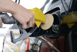 Human's hand filling car with fuel in gas station