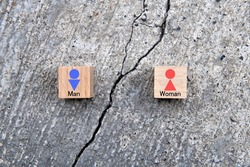 Wooden blocks with man and woman pictogram placed on concrete crack