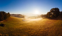 The sun rises thru fog on a cold autumn morning near Kangaroo Ground in the Yarra Valley, Victoria, Australia