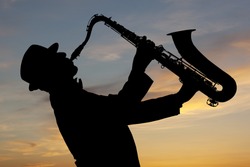 Saxophonist. Man playing on saxophone against the background of sunset