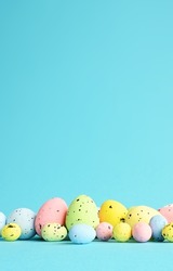 Row of painted colored easter eggs on blue background. Happy Easter background.
