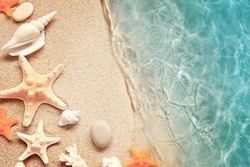 Sea sand with starfish and seashells. Top view with copy space. Summer beach.