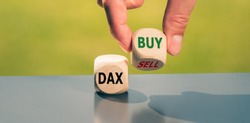 Symbol for buying stocks. Hand turns a cube and changes the word 