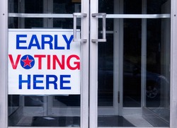 An early voting sign on a door welcoming people to vote for an democratic election in the united states of america.  