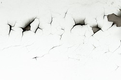 Old white paint on wall. Surface texture with cracked peeling paint. Close-up background.