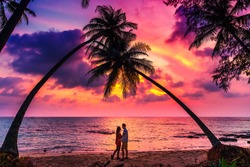 Silhouette of romantic affectionate couple kissing at sunset sea beach. Dating and relationship background with copyspace. Man and woman in love in honeymoon vacation.