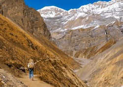 Trekker walking on footpath in the himalayas on the Annapurna Circuit Trek