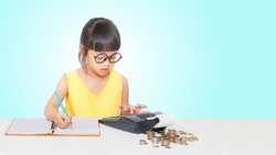 Little girl use caculator and note for money.