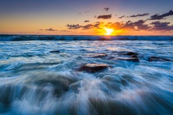 Waves in the Pacific Ocean at sunset, in Laguna Beach, California.