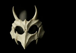 Scary bone monster mask made of silicon photographed on black background hand made and designed by photographer 