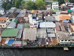 The Slum near riverside, group of house is close, riverside home in danger, unsafe space, city with old plan, Bangkok Thailand