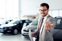 Salesperson at car dealership selling vehicles