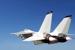 Grumman F-14 Tomcat fighter jet in full speed, two engines with afterburners giving more boost, viewed from behind left