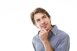 Sympathetic thoughtful man standing with his hand to his chin staring thoughtfully upwards isolated on white